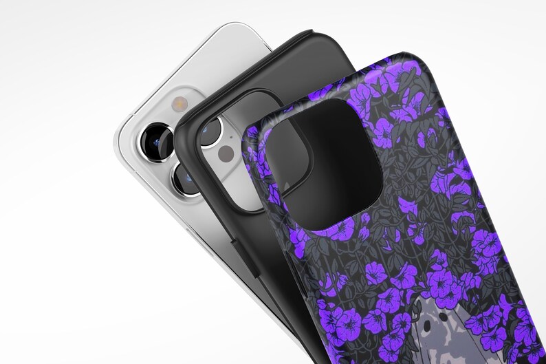 May include: Three phone cases, one clear, one black, and one with a purple floral pattern. The floral pattern case has a small animal peeking out from behind the flowers.