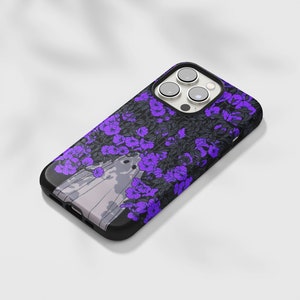 May include: A black phone case with a purple floral design and a ghost in the center. The phone case has a camera lens cutout.