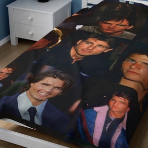 May include: A black and white collage of a man's face. The man is wearing a variety of clothing, including a suit, a t-shirt, and a jacket. The collage is printed on a bedspread.