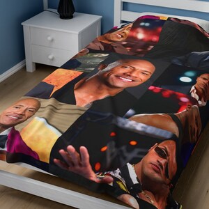 May include: A black and white twin-sized bedspread with a collage of images of Dwayne Johnson, also known as The Rock. The images are in various poses and settings, including a wrestling ring, a movie set, and a red carpet event.