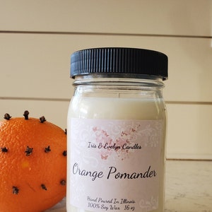 Orange Pomander scented candle, made with high-quality soy wax and a cotton wick for a clean and long-lasting burn. Infused with premium fragrance oils, this candle boasts a delightful blend of orange peel, apple, and peppercorn.