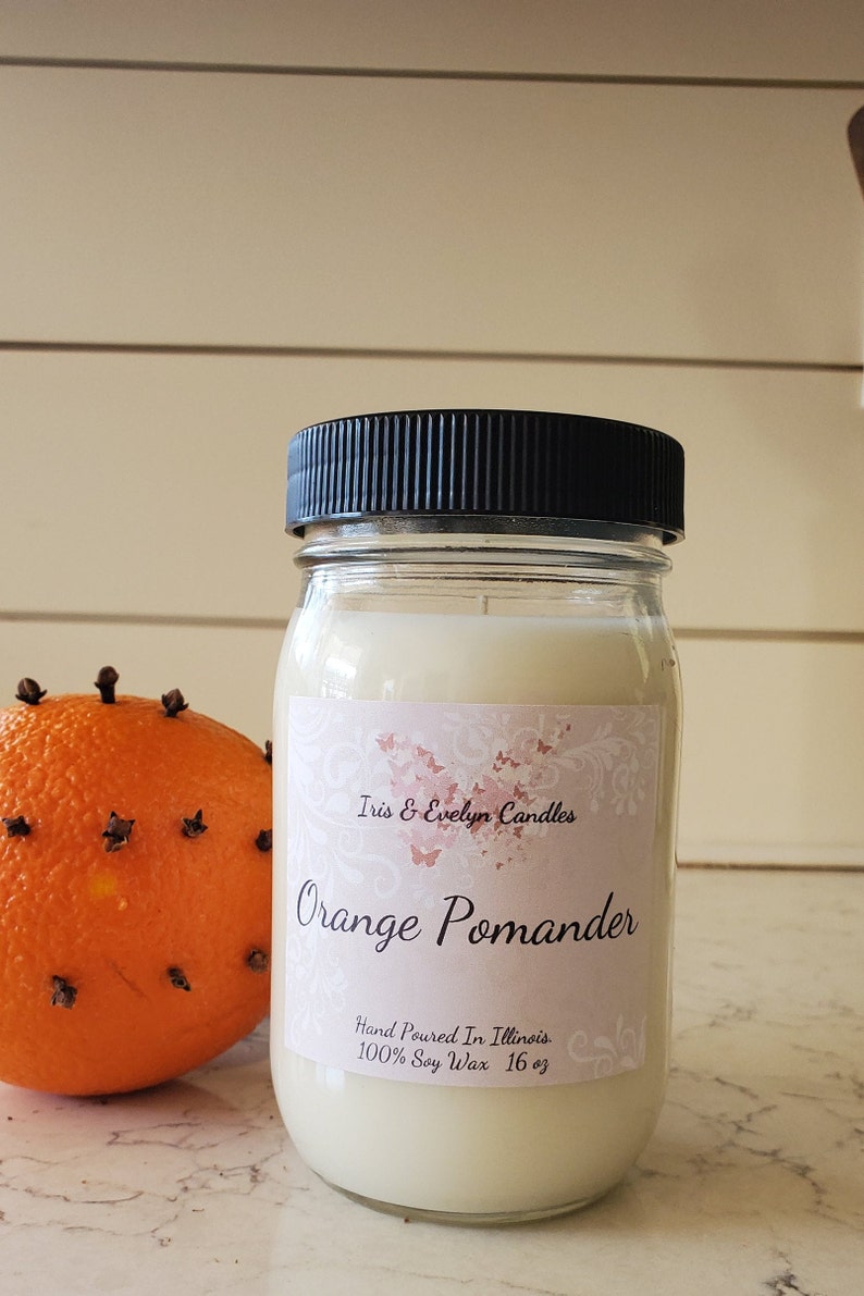 Orange Pomander scented candle, made with high-quality soy wax and a cotton wick for a clean and long-lasting burn. Infused with premium fragrance oils, this candle boasts a delightful blend of orange peel, apple, and peppercorn.