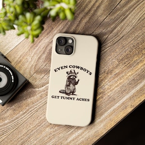Funda para iPhone con mapache y vaquero con dolor de barriga: un divertido meme