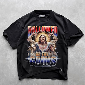 May include: Black t-shirt with a graphic print of three figures with the text "HALLOWED BE THY GAINS".