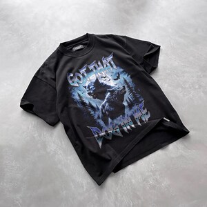 Pode incluir: Camiseta preta com uma estampa gr&aacute;fica de dois lobos uivando para a lua em uma floresta. O texto "GOT THAT DOG IN ME" &eacute; impresso em uma fonte met&aacute;lica abaixo dos lobos.