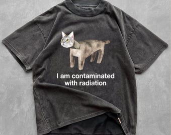 May include: A black t-shirt with a pixelated image of a cat and the text "I am contaminated with radiation".