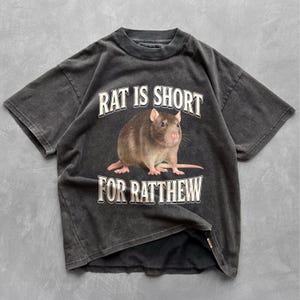 May include: A black t-shirt with a rat graphic and the text "Rat is short for Ratthew".