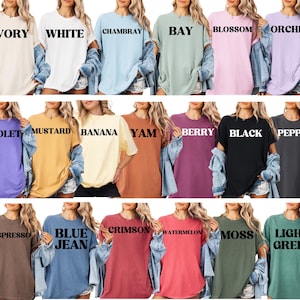 May include: A collection of oversized t-shirts in various colors, including ivory, white, chambray, bay, blossom, orchid, violet, mustard, banana, yam, berry, black, pepper, espresso, blue jean, crimson, watermelon, moss, and light green. Each shirt has a different color name printed on it.