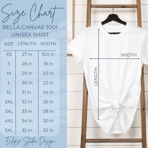 May include: White Bella Canvas 3001 unisex shirt on a black hanger. The image includes a size chart with measurements in inches for sizes XS to 5XL. The chart shows length and width measurements for each size. The text "Eclipse Studio Design" is at the bottom.