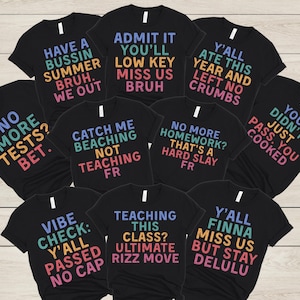 May include: A collection of black t-shirts with colorful text. The shirts feature phrases like "Have a Bussin Summer Bruh," "Admit It You'll Miss Us Bruh," and "Y'all Ate This Year and Left No Crumbs." The shirts are casual wear.