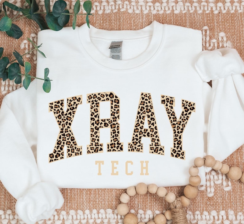 May include: White sweatshirt with a leopard print graphic that says "XRAY TECH" in a collegiate font.