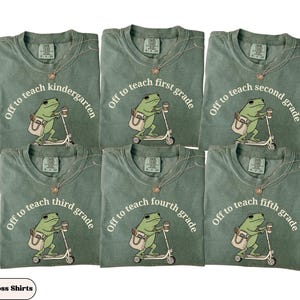 May include: Six green t-shirts with the text "Off to teach" followed by "kindergarten", "first grade", "second grade", "third grade", "fourth grade", and "fifth grade". Each shirt features a frog riding a scooter with a coffee cup and bag.