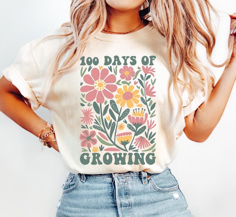 May include: A white t-shirt with a floral design and the text "100 Days of Growing". The flowers are pink, yellow, and green.