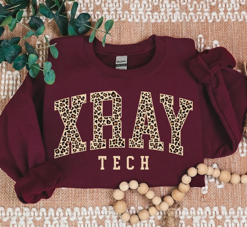 May include: Burgundy sweatshirt with the word "XRAY" in leopard print letters and the words "TECH" underneath.