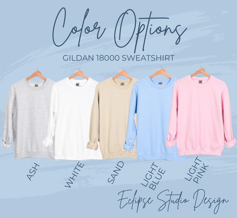 May include: A display of Gildan 18000 sweatshirts in various colors: ash, white, sand, light blue, and light pink. The text "Color Options" and "Eclipse Studio Design" are also visible.