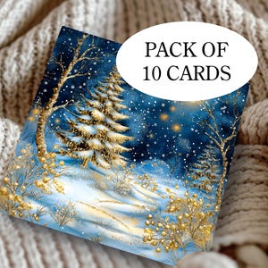 Op de afbeelding: Een pakje van 10 kaarten met een winterlandschap. De kaarten tonen een besneeuwd bos met gouden accenten op de bomen en het gebladerte, tegen een donkerblauwe lucht met vallende sneeuw. De tekst "PACK OF 10 CARDS" is zichtbaar op de kaart.