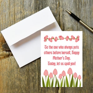 May include: A white card with pink flowers and the text "To the one who always puts others before herself, Happy Mother's Day. Today, let us spoil you!"