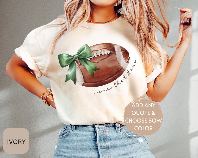 May include: Ivory t-shirt with a green bow and a watercolour football with the text "we are the titans".