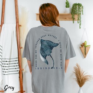 May include: A grey t-shirt with a graphic of a stingray and the text "WHEN YOU GO THROUGH DEEP WATERS, I WILL BE WITH YOU". The stingray is blue and white with a starry design. The word "Grey" is printed at the bottom.