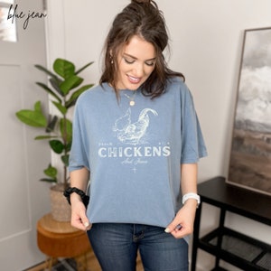 May include: A light blue t-shirt with a white graphic of a rooster and the text "PSALM 91:4 CHICKENS And Jesus".