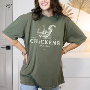 May include: Sage green oversized t-shirt with a white graphic of two chickens and the text "PSALM 91:4 CHICKENS And Jesus".
