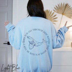May include: Light blue sweatshirt with a whale graphic and the text "When you go through deep waters I will be with you Isaiah 43:2".