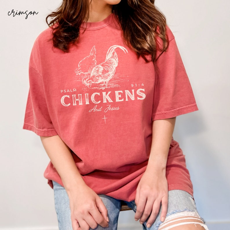 May include: A red t-shirt with a white graphic of two chickens and the text "PSALM 91:4 CHICKENS And Jesus".
