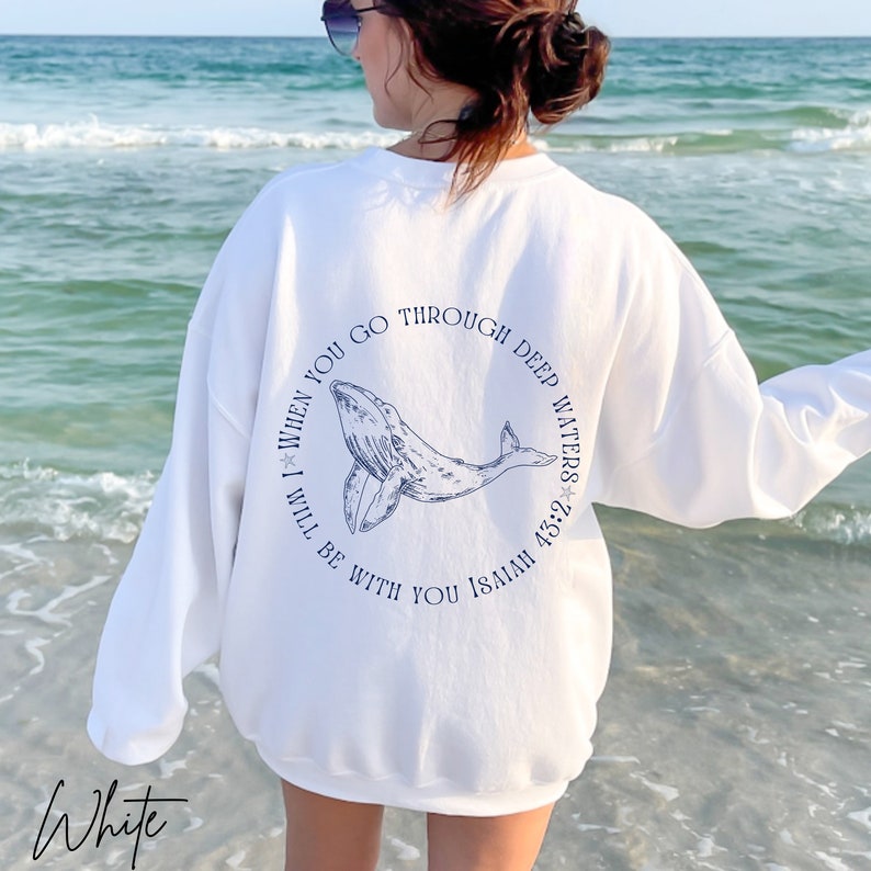 May include: White sweatshirt with a blue whale graphic and the text "When you go through deep waters I will be with you Isaiah 43:2" on the back.