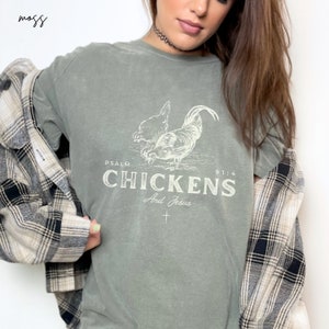 May include: A green t-shirt with a white graphic of two chickens and the text "PSALM 91:4 CHICKENS And Jesus".