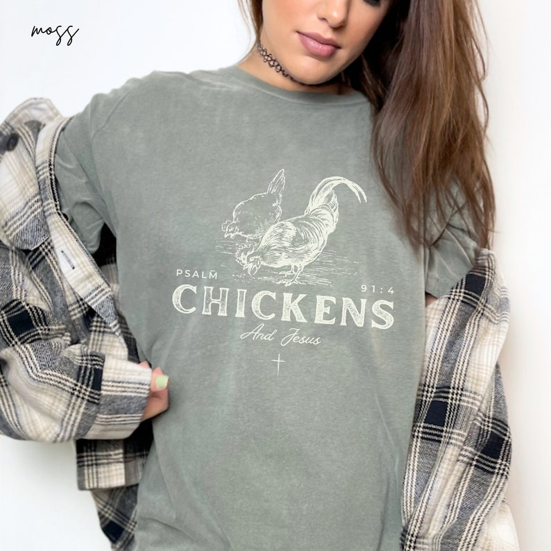 May include: A green t-shirt with a white graphic of two chickens and the text "PSALM 91:4 CHICKENS And Jesus".