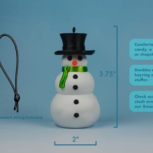 An infographic of the snowman Christmas money holder showing its size of about four inches tall, the included ornament string, and the hidden compartment that fits cash, candy, chapstick, or a note.
