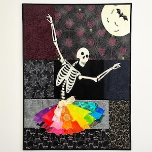 May include: A Halloween-themed quilt featuring a skeleton in a rainbow tutu, set against a backdrop of various patterned fabrics. The design includes a full moon with bats, spiderwebs, and hearts, creating a festive and colorful artwork.