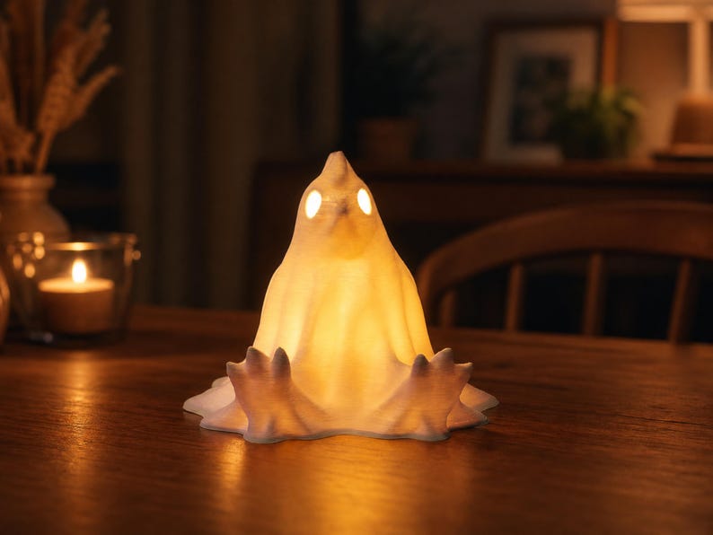 A funny glowing fowl sits lazily with its legs sticking straight out on a dining table at night. A lit candle sits to one side, complementing the warm glow of this cute spooky led lamp. This chicken ghost figure provides cozy witchy accents and weirdcore room decor. As a pastel goth oddity and macabre desk bird, it enhances your alt dark aesthetic. Perfect for goblincore dopamine gifts and whimsigoth styling, this tea light holder alternative makes an incredible cute spooky nightstand lamp.