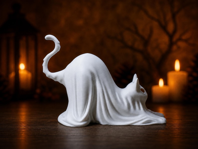 A right-side profile of the stretching ghost cat statue, showing its curly tail. This piece acts as a creepy cute fall decoration on a wooden mantle.
