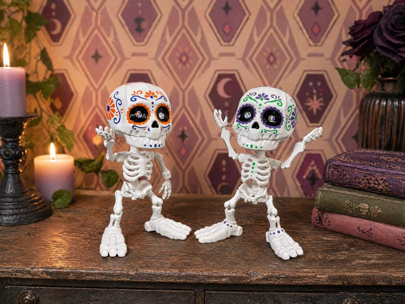 Two articulated skeletons posed in the middle of a lively, animated conversation, with one raising both hands and the other raising one. This playful scene demonstrates the extreme posability of this weirdcore desk fidget toy. A brilliant coworker gag gift and gothic tactile sensory item decor piece. This sugar skull figure is an engaging ADHD fidget tool for office desks and serves as the perfect witchy gift for friend or fun dopamine decor.