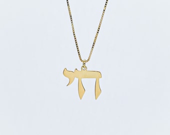 May include: A gold chain necklace with a pendant shaped like the Hebrew letter Chai.