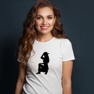 May include: A white t-shirt with a black silhouette of a woman wearing a cowboy hat and boots.