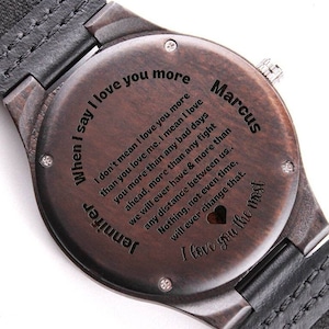 May include: A dark brown wooden watch with a black leather band. The back of the watch has a personalized message engraved on it that reads: "When I say I love you more I don't mean I love you more than you love me. I mean I love you more than any bad days ahead, more than any fight we will ever have & more than any distance between us.. Nothing, not even time, will ever change that. I love you the most"  The watch also has the name "Marcus" engraved on the back.