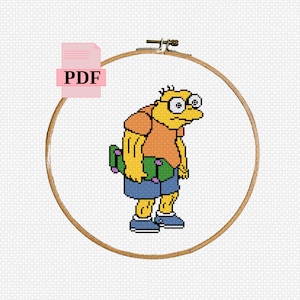 Puede incluir: Patrón de punto de cruz de un personaje de dibujos animados amarillo con gafas que sostiene una patineta verde. El patrón está en un aro de bordado de madera circular.