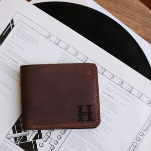 The handmade leather wallet, which is 3.5 inches wide and 4.3 inches tall, has 10 card pockets and 1 cash pocket, is available in 6 different colors: brown, light brown, red, gray, blue, green and black. The personification on it is laser engraved.