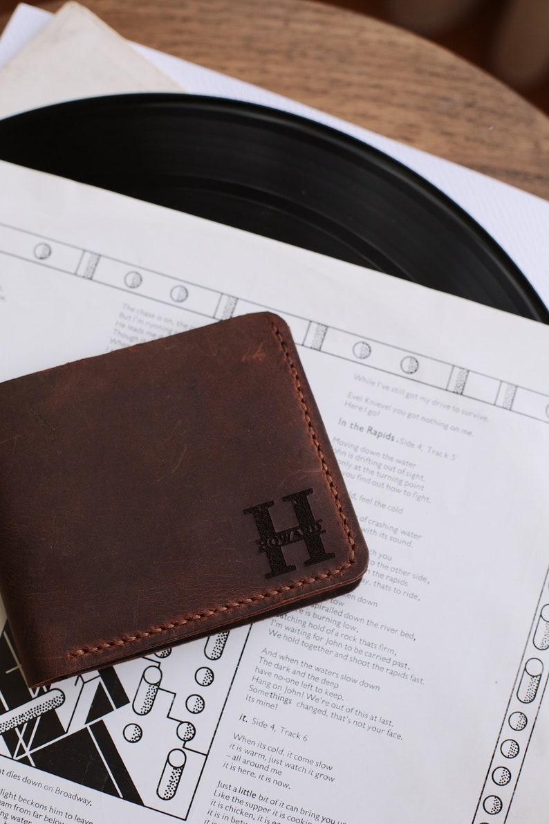 The handmade leather wallet, which is 3.5 inches wide and 4.3 inches tall, has 10 card pockets and 1 cash pocket, is available in 6 different colors: brown, light brown, red, gray, blue, green and black. The personification on it is laser engraved.