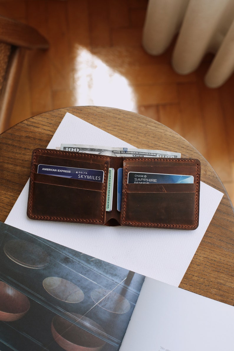 The handmade leather wallet, which is 3.5 inches wide and 4.3 inches tall, has 10 card pockets and 1 cash pocket, is available in 6 different colors: brown, light brown, red, gray, blue, green and black. The personification on it is laser engraved.