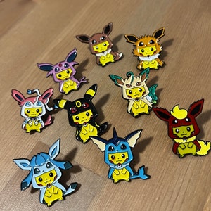 Pu&ograve; includere: Un set di dieci spille smaltate con diversi personaggi di Pok&eacute;mon. Le spille sono tutte in stile cartone animato e presentano i personaggi in varie pose. Le spille sono tutte di colori diversi e hanno una finitura lucida.
