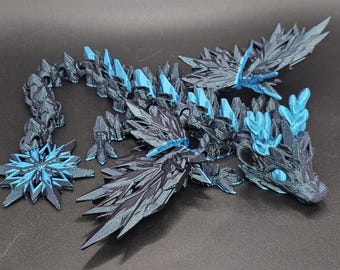 May include: A black and blue 3D printed dragon figurine with intricate details and a spiky design. The dragon has wings, a long tail, and a fierce expression.