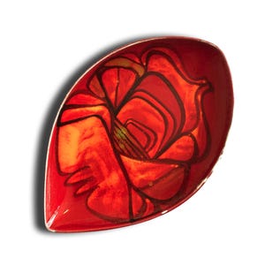 Può includere: Un piatto decorativo rosso a forma di foglia con un motivo floreale. Il piatto presenta una finitura lucida e un colore rosso vibrante. Il motivo floreale è delineato in nero, con sfumature di arancione e giallo al centro.
