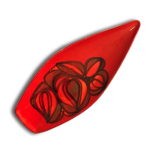 May include: A red, leaf-shaped ceramic dish with a floral design. The dish has a glossy finish and features a hand-painted design in shades of red, brown, and black. The decorative dish is ideal for serving snacks or as a decorative accent.