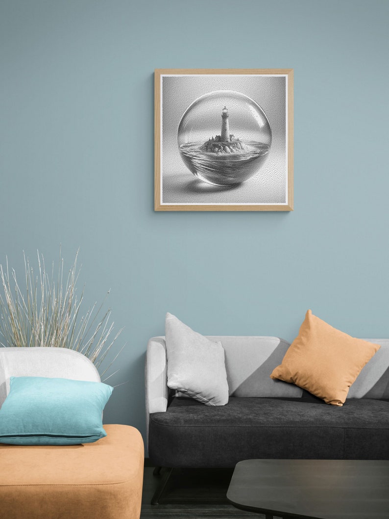 May include: A black and white drawing of a lighthouse on a small island inside a glass sphere. The drawing is framed in a light wood frame and hanging on a light blue wall.