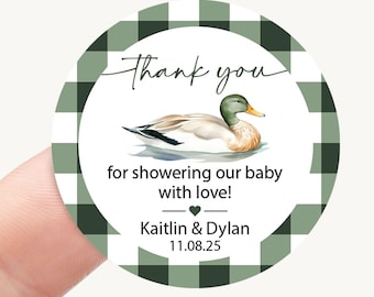 May include: A round sticker featuring a dark green and white buffalo plaid border. The center displays a mallard duck illustration with the text: Thank you for showering our baby with love! Kaitlin & Dylan 11.08.25.