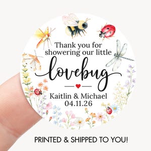 May include: A round sticker with a floral border and watercolor illustrations of insects. The text reads "Thank you for showering our little lovebug" with the names Kaitlin & Michael and the date 04.11.26.