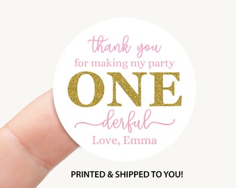 May include: Round white sticker with pink and gold text. The text reads "thank you for making my party ONE derful Love, Emma".